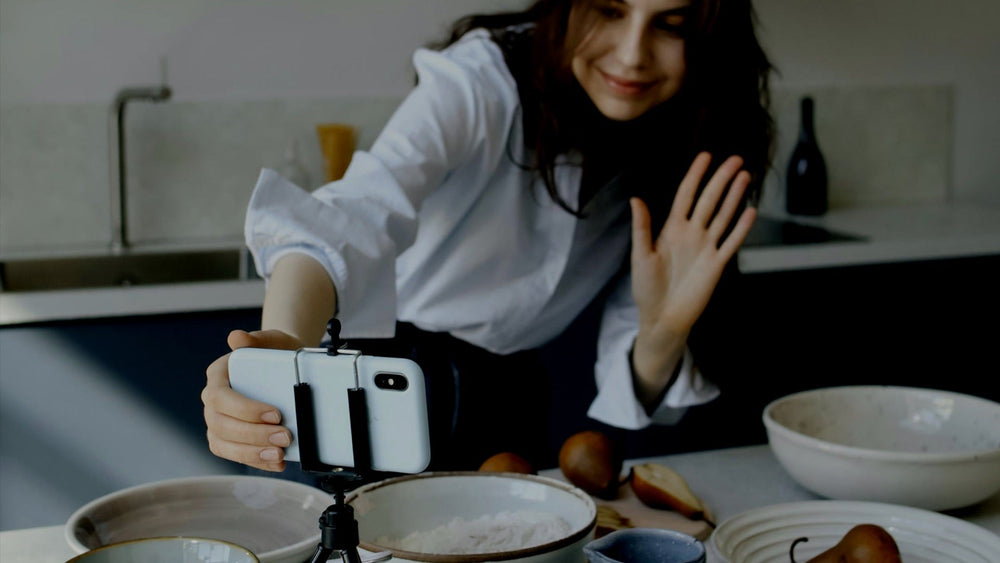 Woman recording a live video of plating food.